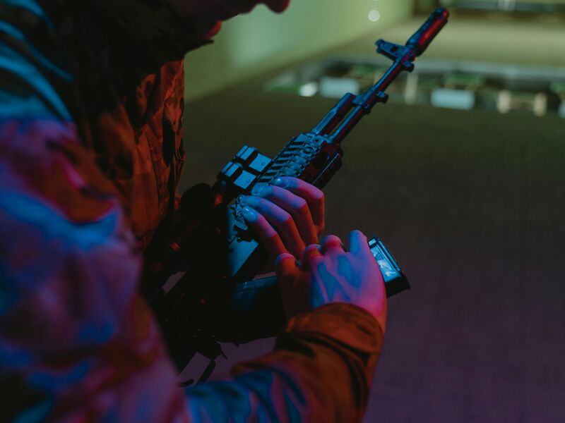Tactical rifle handling with red and blue lighting